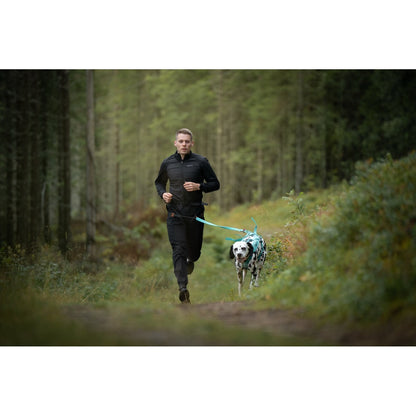 Mies juoksee dalmatiankoiran kanssa metsäpolulla Non-stop CaniX Belt 3.0 -vetovyö päällään
